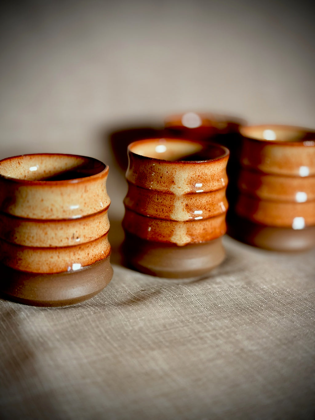 Handmade stoneware water cups with rust glaze and ribbed texture