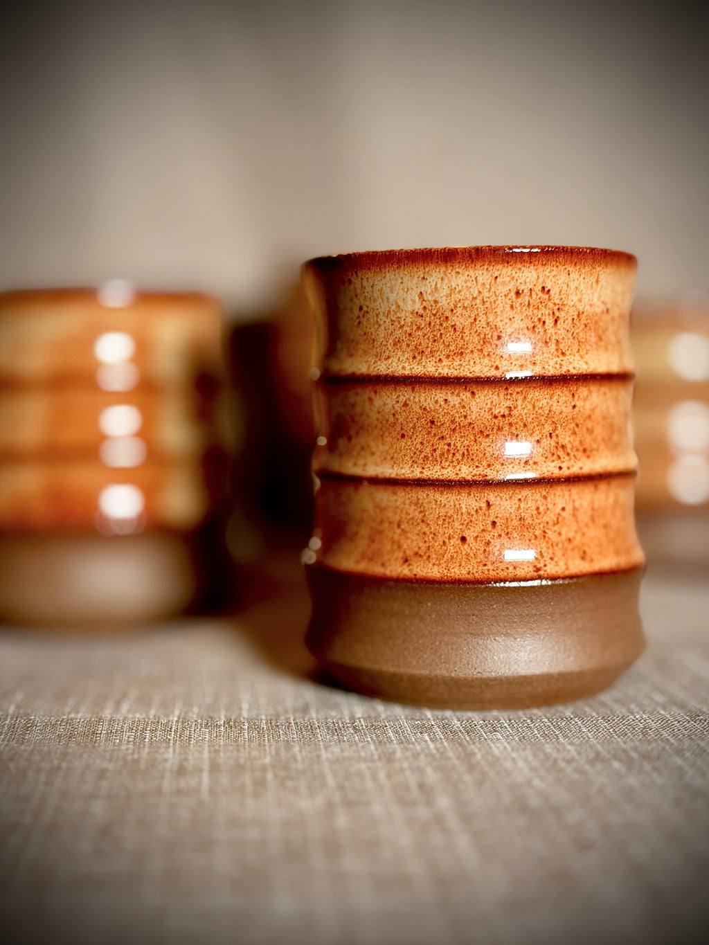 Stacked ceramic water cups in rust and grey stoneware by VanWest Studios