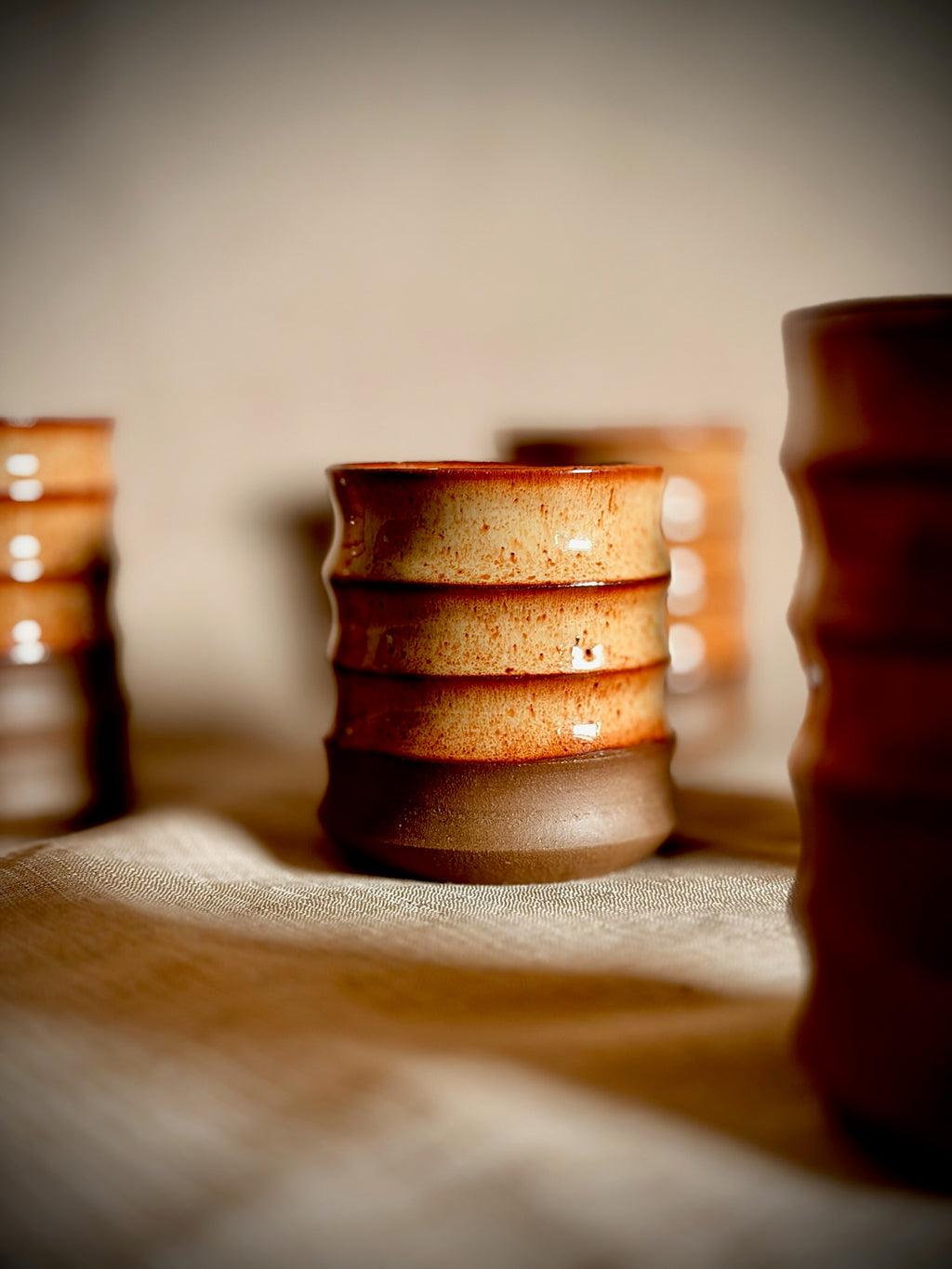 Ribbed stoneware water cups in rust glaze, hand-thrown in small batches