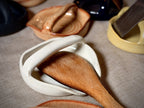 Wooden spoon resting in a handmade stoneware spoon rest